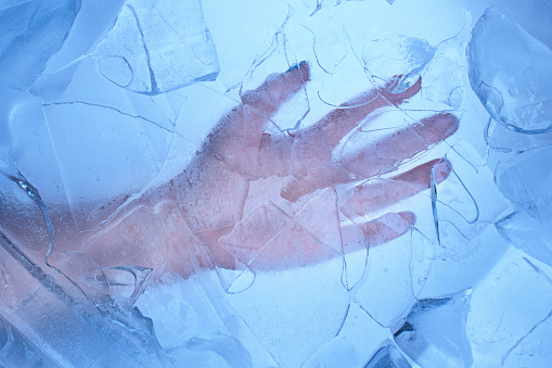 Close-up woman's palm through an ice floe. winte cold concept