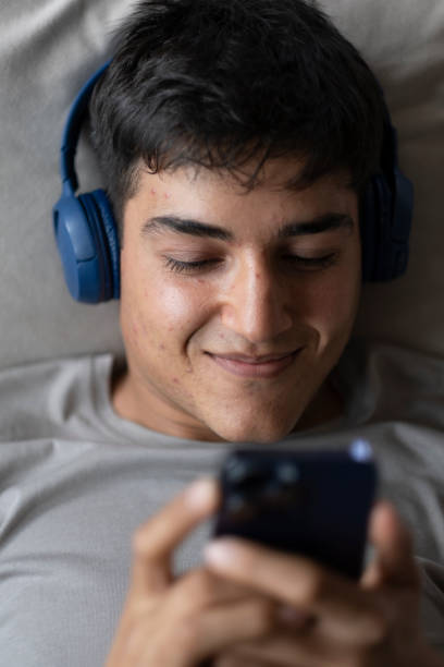 istock handsome young man texting on phone while listening to music 1495898347