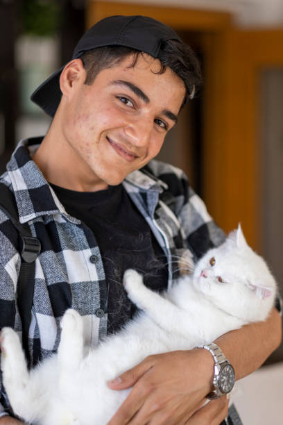 istock handsome young man loving his cat on his lap 1495898459