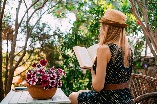 Young Woman Reading a Book in the Garden