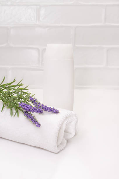 istock White bottle mockup with towel and lavender on table in bathroom. Cleanliness care. vertical. copy space 1495898669