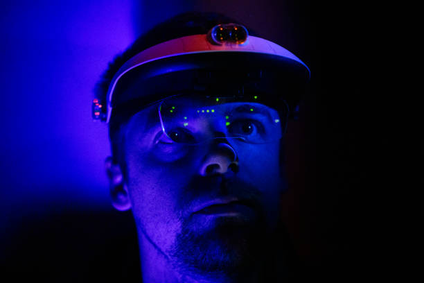 istock Data center multi colour reflections in protective glasses on males face in warm purple light 1495900132