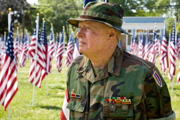 Decorated American Veteran with military ribbons, in uniform in a sea of American Flags.