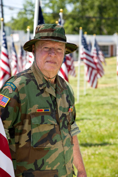 istock Vietnam War Combat Veteran standing with American Flags 1495901738