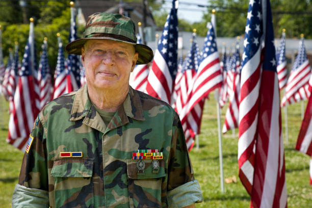 istock Vietnam War Combat Veteran with slight smile among American Flags 1495901762