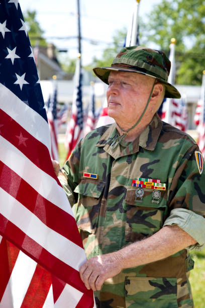 istock Vietnam War Combat Veteran straitening  American Flag 1495901768