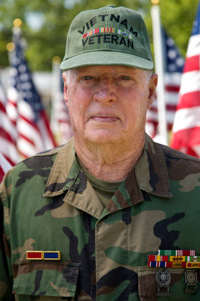 istock Vietnam War Veteran among Flags looking at camera 1495901798
