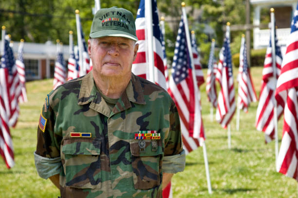 istock Vietnam War Veteran among Flags standing at ease 1495901848