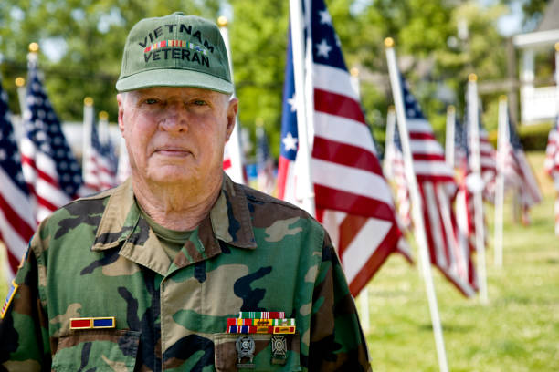 istock Vietnam War Veteran with Flags looking at camera 1495901889