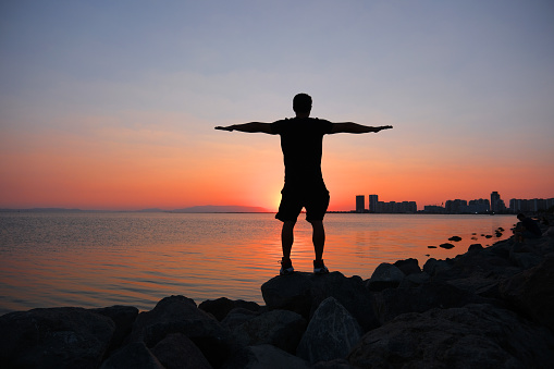 silhouette of young man doing sports at sunset