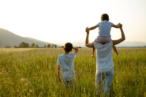 istock Family watching the sunset on the meadow. 1495904692