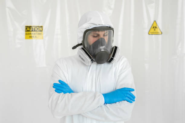 istock Man in protective suit, goggles, blue rubber gloves and respirator. 1495905360