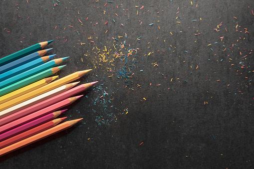 Sharpening colored pencils, black paper background