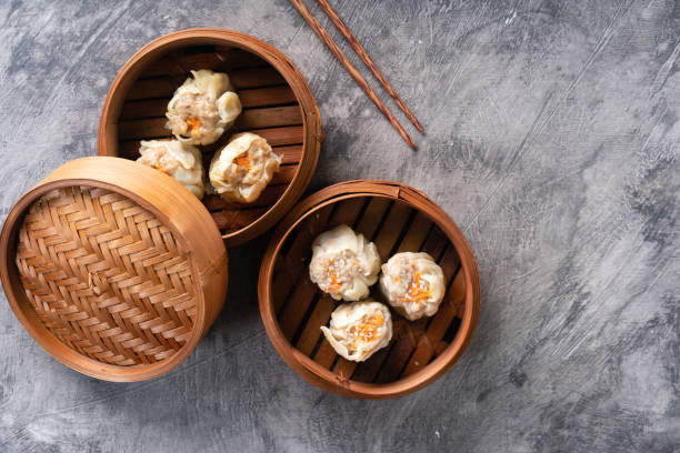 istock Chinese steamed dumplings or  Dim Sum in bamboo steamer on dark abstract background 1495907893