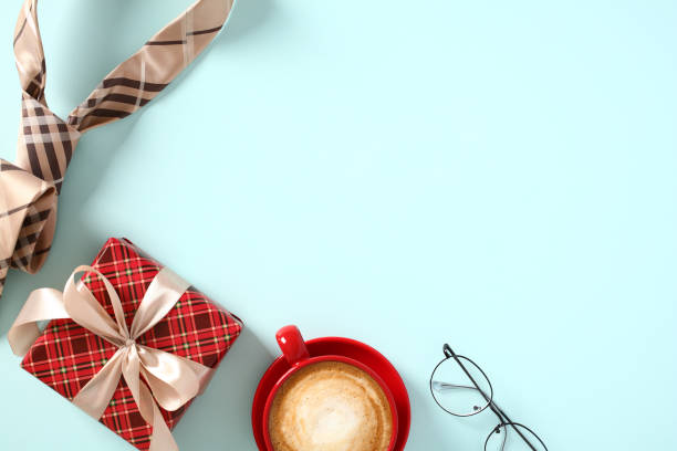 istock Happy Fathers Day concept. Top view vintage gift box, red coffee cup, glasses, tie on blue table. 1495919344
