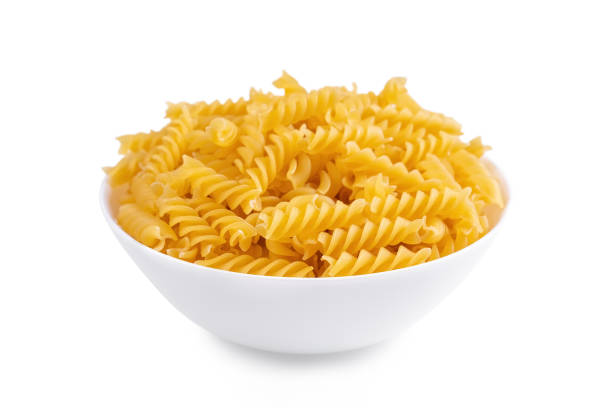 istock Raw pasta in bowl isolated on white background 1495920514