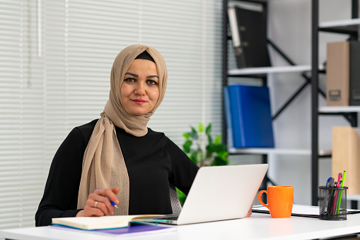 Portrait of Muslim Businesswoman Wearing Hijab Works on Laptop