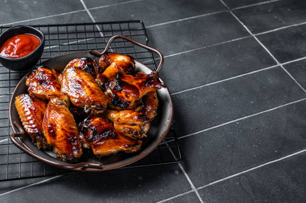 istock BBQ chicken wings in dip Barbecue sauce. Black background. Top view. Copy space 1495922789