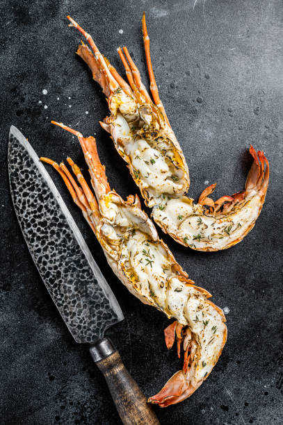 istock BBQ Grilled Spiny lobster sliced on a cutting board Black background. Top view 1495922866