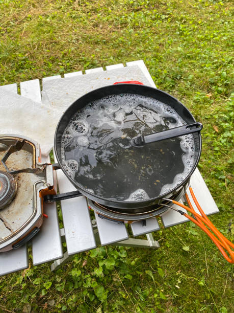 istock Washing cooking pan on camping stove 1495922984