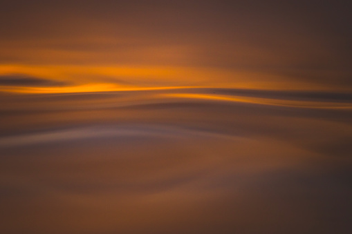 Golden abstract patterns on ocean surface from sunrise, photographed in the water on the coast of South Eastern Australia.