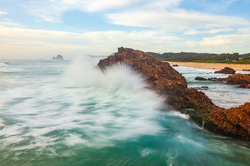 Seascape of waves breaking against coastal rock formations, photographed on the coast of South East Australia.