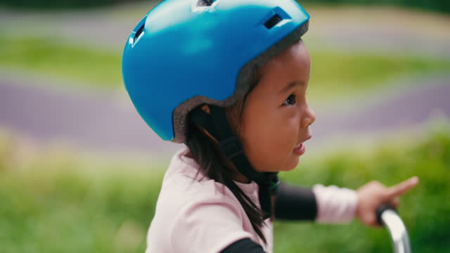 daughter learns bike riding in park.