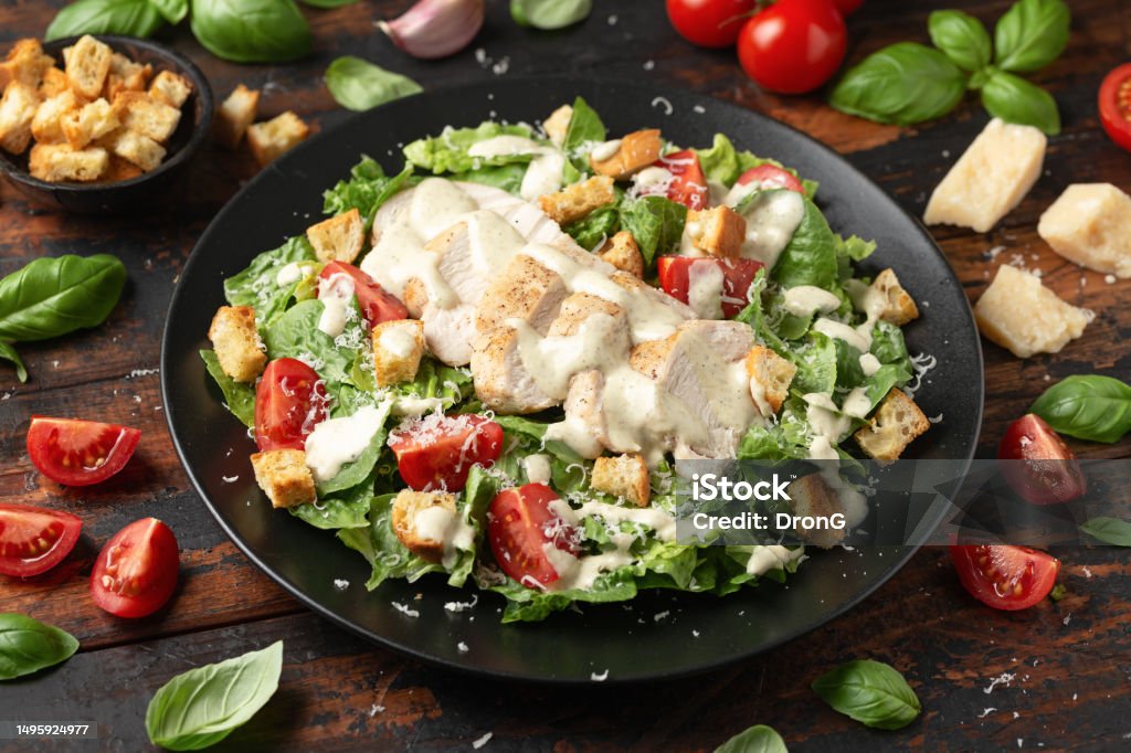 A delicious chicken caesar salad with parmesan cheese, tomatoes, croutons and dressing A delicious chicken caesar salad with parmesan cheese, tomatoes, croutons and dressing. Salad Stock Photo