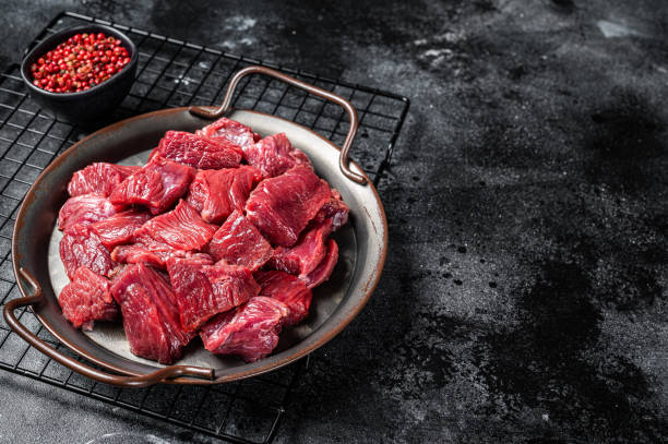 istock Raw Diced venison dear meat for a goulash, game meat. Black background. Top view. Copy space 1495926086