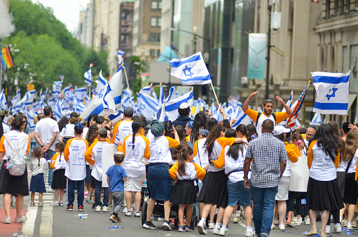 Marchers are seen holding Israeli flags as marchers head up Fifth Avenue, New York City in the annual Salute to Israel Parade on June 4, 2023.