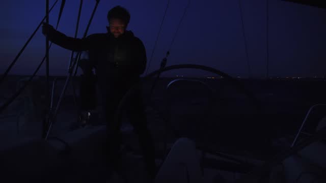 Captain sailing by yacht at night.