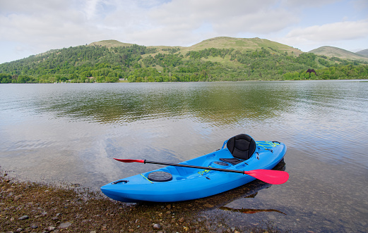 Blue kayak moored at Loch Lomond on island UK