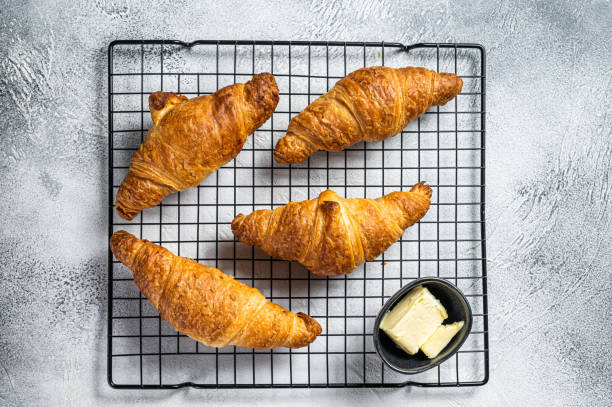 istock Baked Croissants on a cooling rack. White background. Top view 1495928087