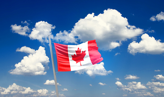 Canada national flag waving in beautiful sky.