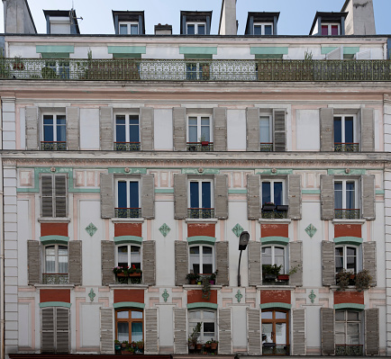 Paris, France - 06 03 2023: View of the facade of a gray and white apartment building