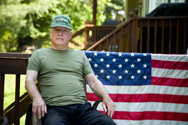 istock Vietnam Veteran sitting wearing cap looking at camera 1495932726