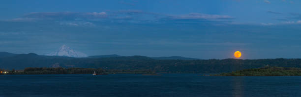 Panoramic landscape of the June 2023 full strawberry moon rising over the Columbia River with Mt Hood, Oregon