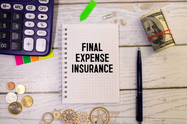 istock Final Expense Insurance write on a book isolated on Wooden Table. 1495942029