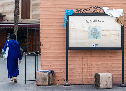 Qzadriya Square (Tinsmiths Square) at Mellah District (Jewish Quarter) in Marrakesh, Morocco, with a woman walking past.