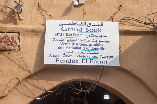 Grand Souk in Medina District of Marrakesh, Morocco, with writing that includes several languages.