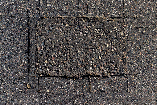 Damaged asphalt pavement , close up of a damaged and defective road