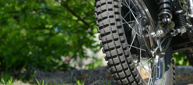 Off road parked motor bike close up of the rear tire from behind