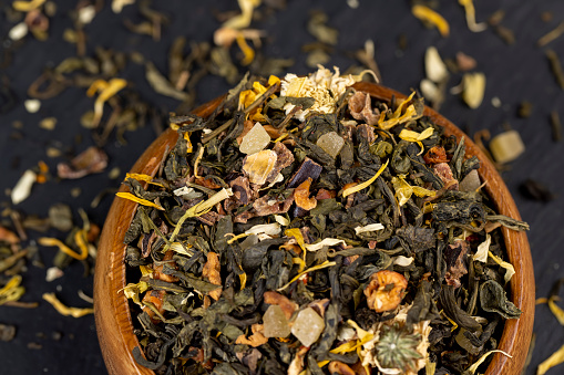 A large amount of dry green tea with pieces of fruit, delicious and fragrant green tea with a pleasant aroma