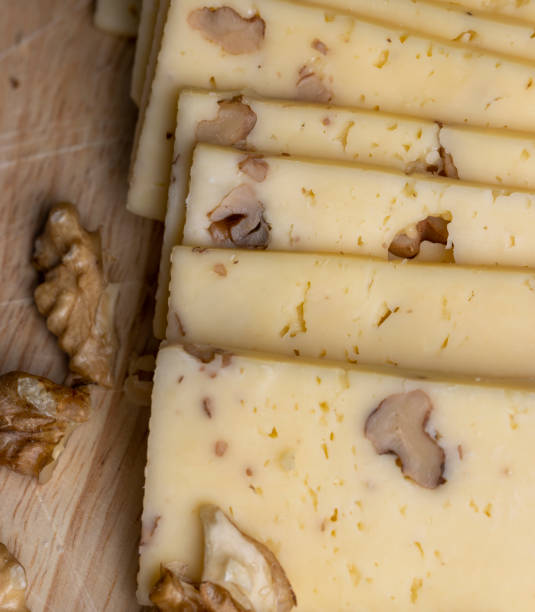 istock Sliced piece of milk cheese with walnuts 1495953156
