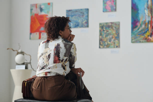 istock Woman looking at paintings on the wall 1495954850