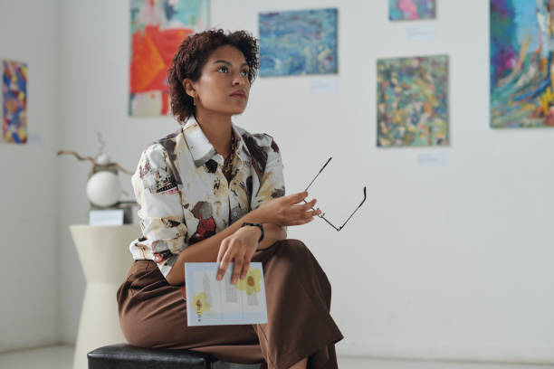 istock Pensive woman sitting in art gallery 1495954884