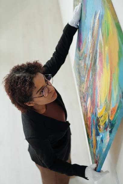istock Gallerist hanging new paintings in gallery 1495955025