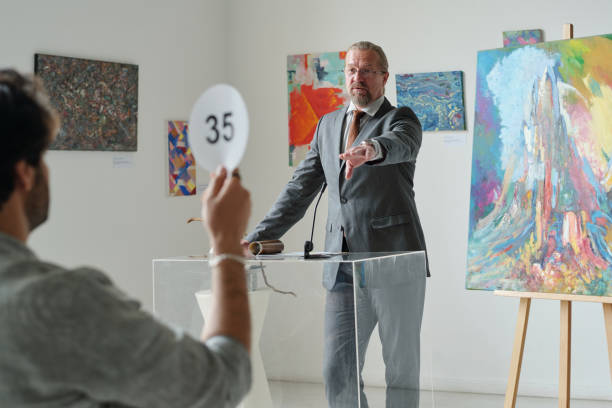 istock Man holding auction in art gallery 1495955812