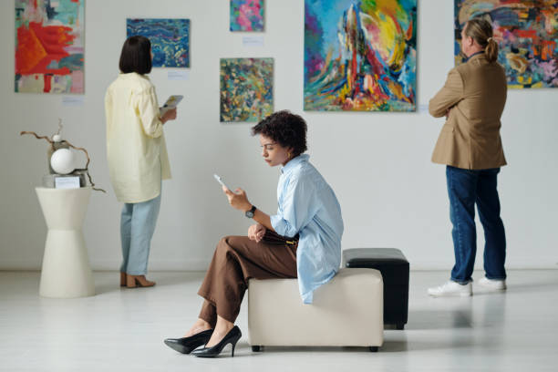 istock Woman using smartphone in art gallery 1495956153