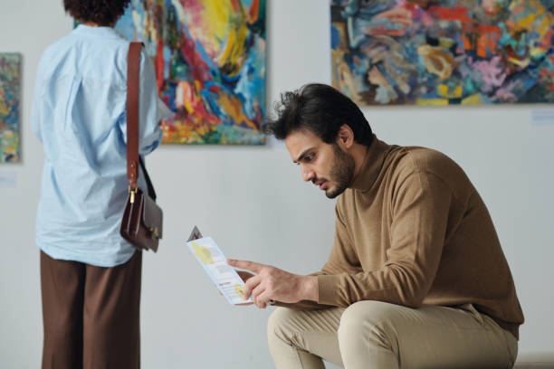 istock Man examining brochure at exhibition 1495956175
